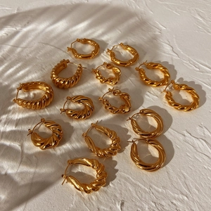 Chunky gold-plated stainless steel twisted hoop earrings in various sizes with leaf shadows