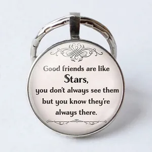 Detail of round keychain featuring glass gem with friendship quote about stars