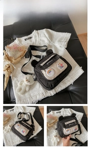 Detail of black canvas crossbody bag with cute rainbow badge and white plush bear charm
