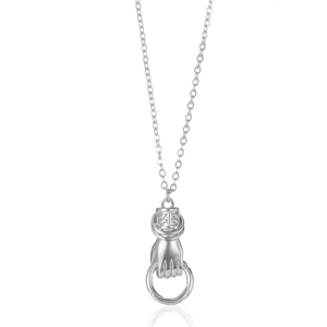 Macro detail of silver necklace featuring hand-holding ring pendant and fine chain links