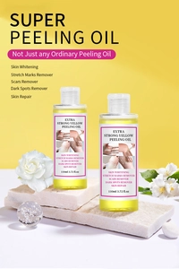 Close-up of two 110ml yellow peeling oil bottles on white stone with gardenia flower