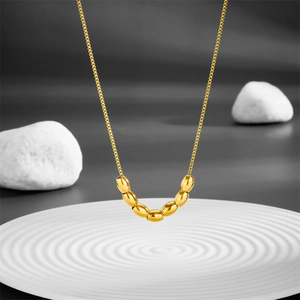 Minimalist gold titanium steel necklace with seven oval beads on white textured disk