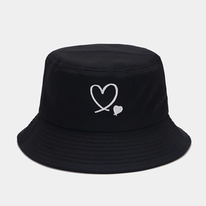 Detail of white heart embroidery on black cotton twill bucket hat with clean texture