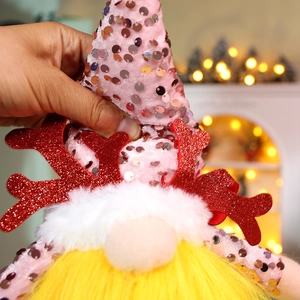 Close-up of pink sequined Christmas gnome with glitter antlers and soft faux fur beard