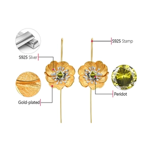 Detailed macro view of gold-plated S925 silver flower earrings with peridot center stones