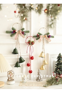 Close-up of colorful Christmas bells with pine needles and berries hanging on a wall