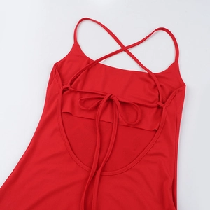 Detail of red elegant dress featuring an open back with cross-strap and lace-up bow design