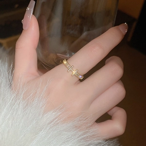 Detail of gold-plated cross ring with tiny cubic zirconia on an elegant model hand