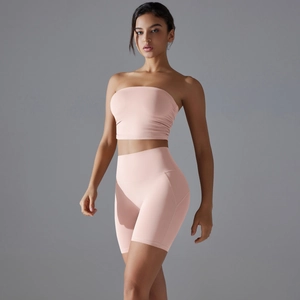 Detailed studio shot of pink seamless yoga set featuring a bandeau top and biker shorts