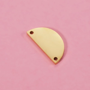 Close-up of golden semi-circle stainless steel pendant with double holes for DIY jewelry