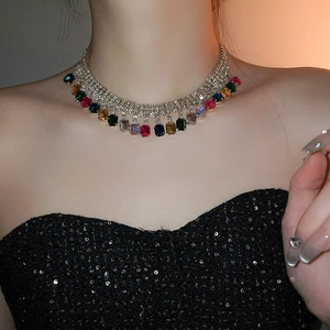 Détail du collier argenté avec strass carrés colorés et pompons à franges élégants