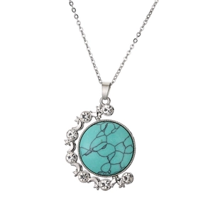 Detail of silver moon pendant with turquoise stone and sparkling white rhinestones
