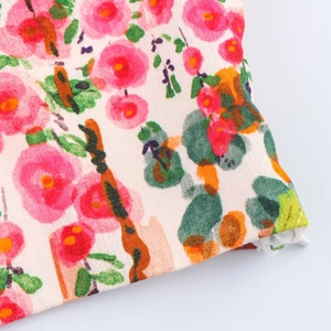 Vue détaillée de l'imprimé floral montrant des fleurs roses et des feuilles vertes
