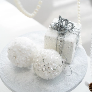 Elegant white foam Christmas balls and gift box ornaments with silver glitter on snow
