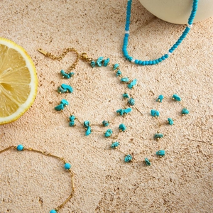 Detail of turquoise stone double-layer gold stainless steel bracelet on stone background