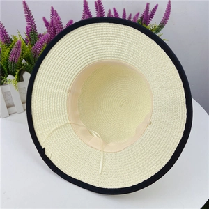 Beige straw sun hat with wide brim, black piping and windproof chin strap shown from inside