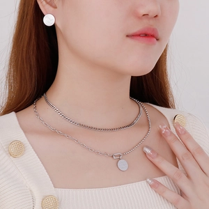 Dettaglio di orecchini Good Luck e collana a doppio strato in acciaio inossidabile argento