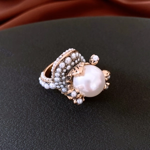 Macro shot of vintage pearl flower ring featuring a large pearl and gold baroque details