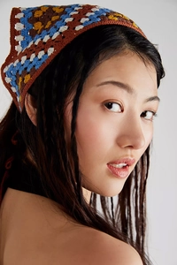 Detailed view of colorful crochet floral headscarf showing intricate handmade knit patterns