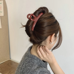 Close-up of elegant burgundy large hair claw clip on long hair for autumn hairstyles