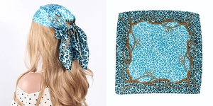 Close-up of blue leopard and gold chain print square satin scarf on model and flat lay
