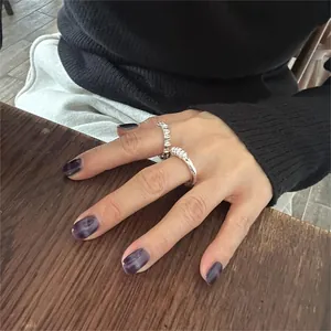 Detail of 925 sterling silver rings with twisted design and fine texture on fingers