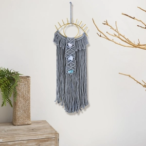Detail of handcrafted macrame wall hanging with evil eye metal frame and blue raw stones