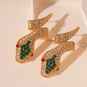 Macro detail of gold snake earrings with green and clear rhinestones and red eye accents