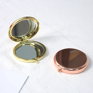 Foldable gold and rose gold metal makeup mirrors with a polished finish on white fabric