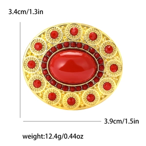 Vintage gold oval brooch with red crystals and gemstones on white background