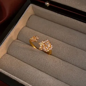 Vintage gold snake ring featuring twin roses with zircon pavé on a dark velvet display