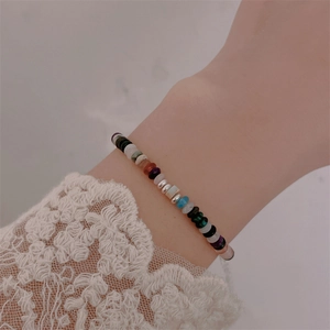 Detail of colorful beaded bracelet with natural stones and silver spacers on woman's wrist