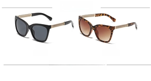 Close-up of black and leopard cat-eye sunglasses with metal chain temple detail