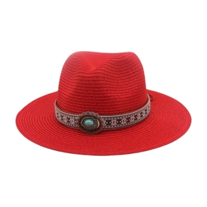 Détail d'un chapeau de paille rouge avec ruban ethnique et ornement en pierre turquoise