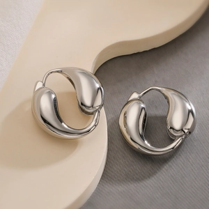 Polished silver dolphin teardrop earrings with a minimalist curved metallic finish