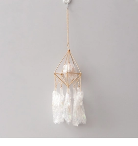 Detailed macro of crystal suncatcher with golden geometric metal frame and iridescent prisms