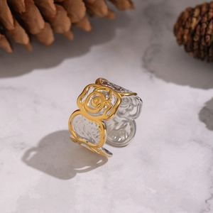 Two-tone rose flower open ring in gold and silver finish with textured relief on marble