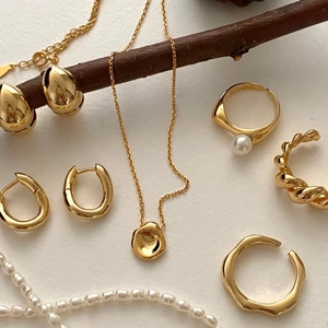 925 silver jewelry set with irregular gold pendants and pearls on natural wood