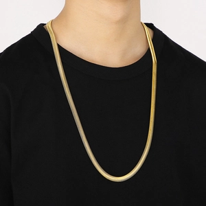 Men's gold flat snake bone chain necklace worn by a model on a black background
