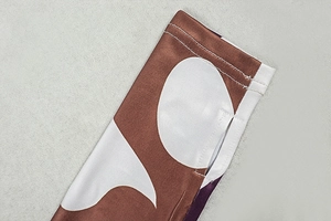 Detail of finger hole cuff on printed dress with flatlock stitching and polka dots