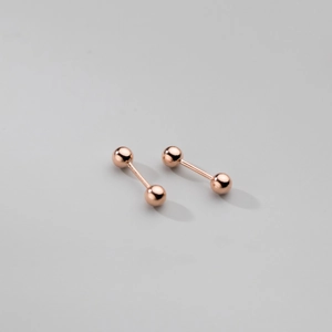 Détail macro de boucles d'oreilles boules minimalistes en argent S925 plaqué or rose chic