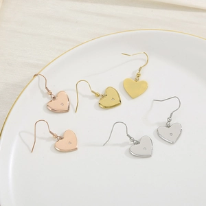 Trois paires de boucles d'oreilles cœur en strass, finitions or, or rose et argent