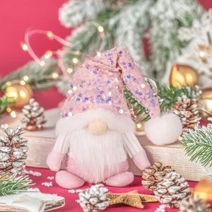 Detail of pink sequin Christmas gnome with fluffy beard and festive holiday ornaments