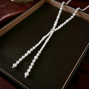 Detail of elegant Y-shaped long necklace with gradient pearls and silver sliding clasp