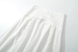 Detailed view of white lace waist trim and pleated texture on women's skirt