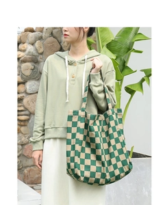 Detail of green and beige checkered canvas tote bag with shoulder strap