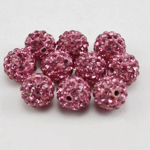 Makroaufnahme von zehn 8mm rosa Pavé-Tonperlen mit funkelnden Straßsteinen für DIY