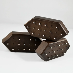 Detail of hexagonal dark brown wooden jewelry stands with holes for stud earrings