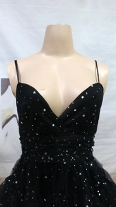 Detailed view of black tulle dress featuring silver star and moon sequins and V-neckline