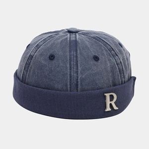 Dettaglio del logo R in metallo sul berretto docker in denim lavato blu navy